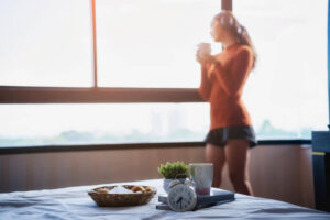 giovane donna beve tisana al mattino prima di fare attività sportiva
